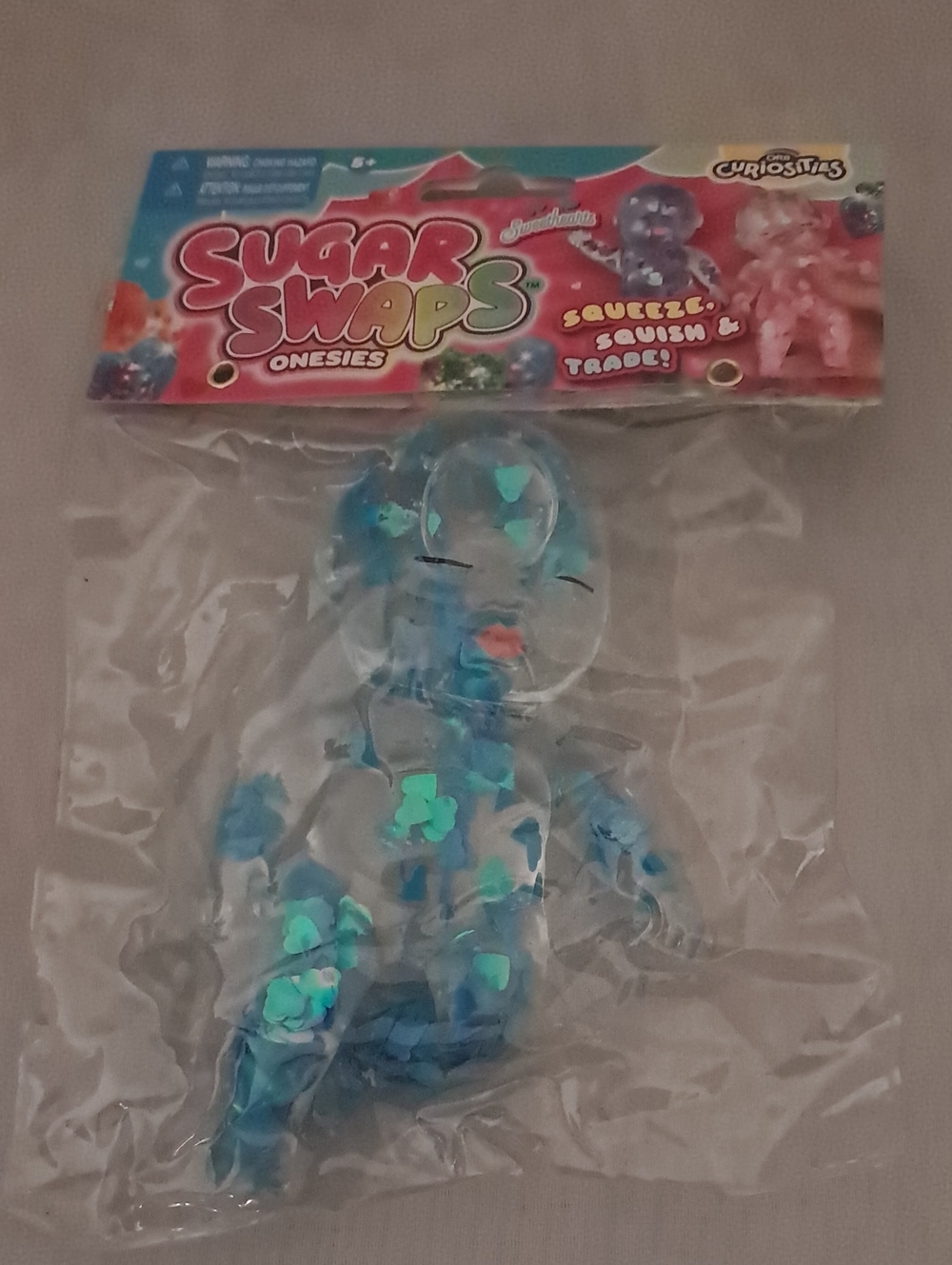 Sugar Swaps Onesies Blue Glitter Squeeze Doll